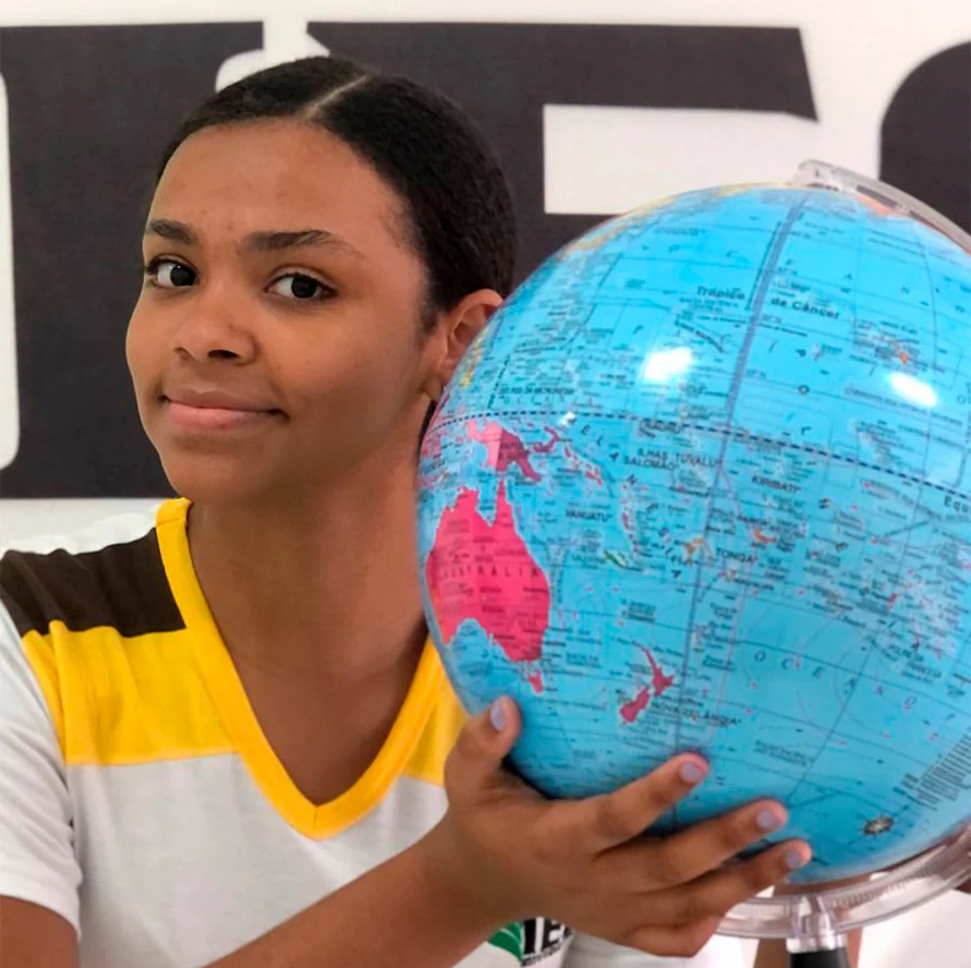 Aluna segurando um globo terrestre
